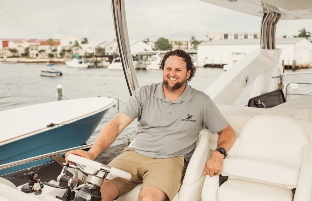 Image of Marcus Shubert, Master Marine Mechanic, sitting at the wheel of a luxury boat.