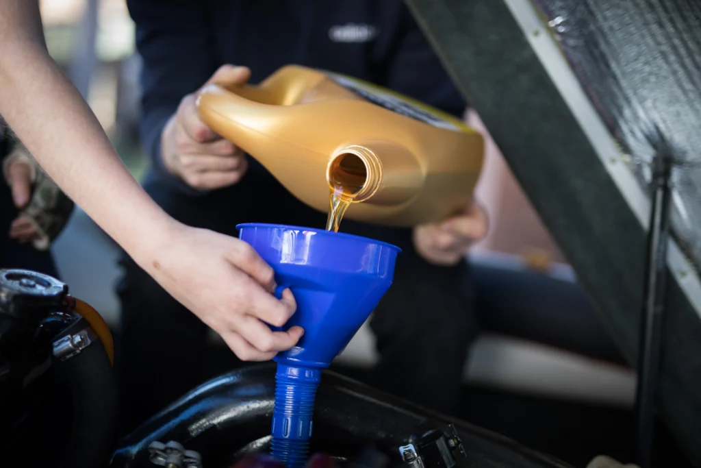 Image of a mechanic adding lubricants to a marine diesel engine